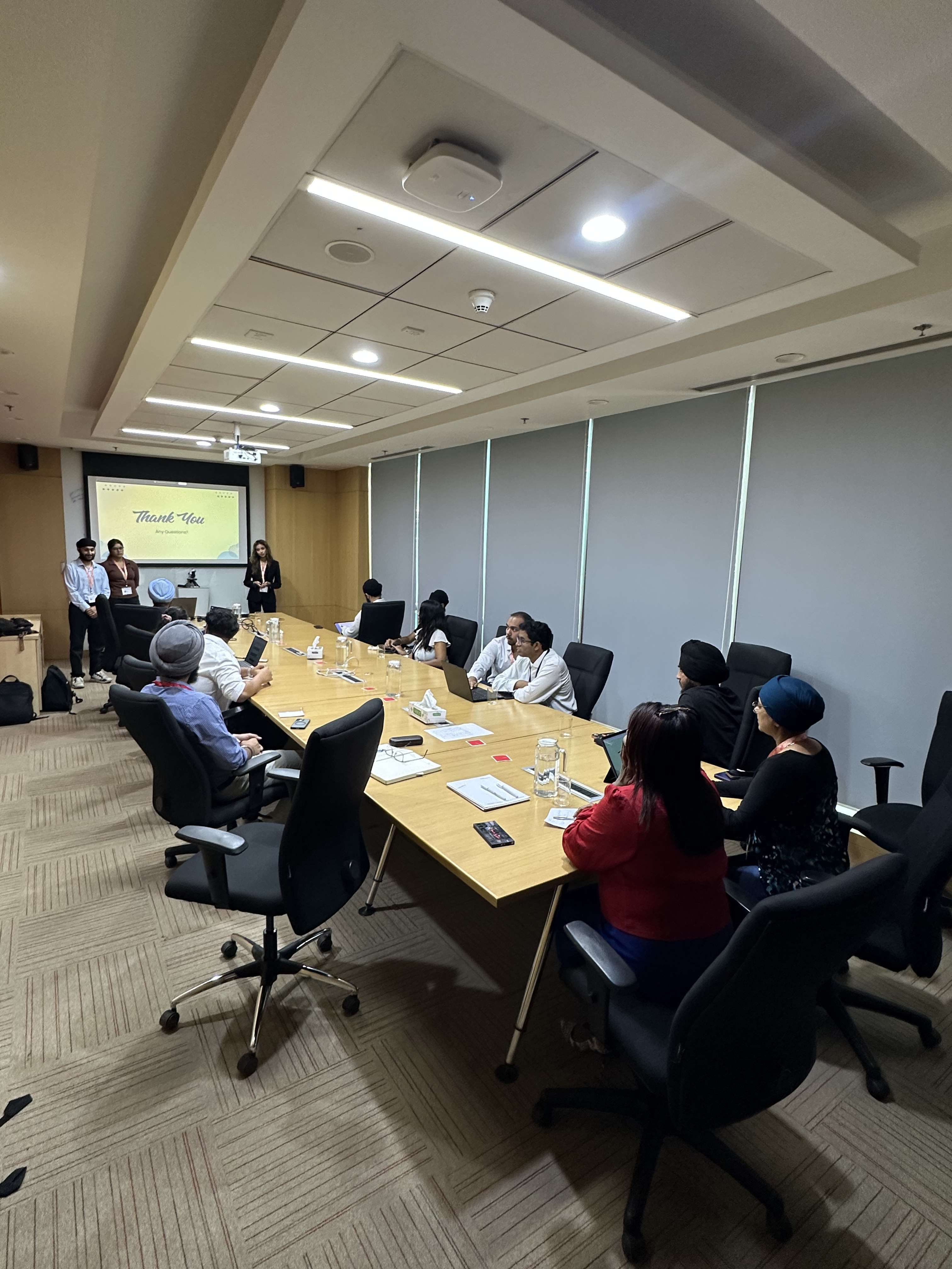 Students presenting in a boardroom to company executives