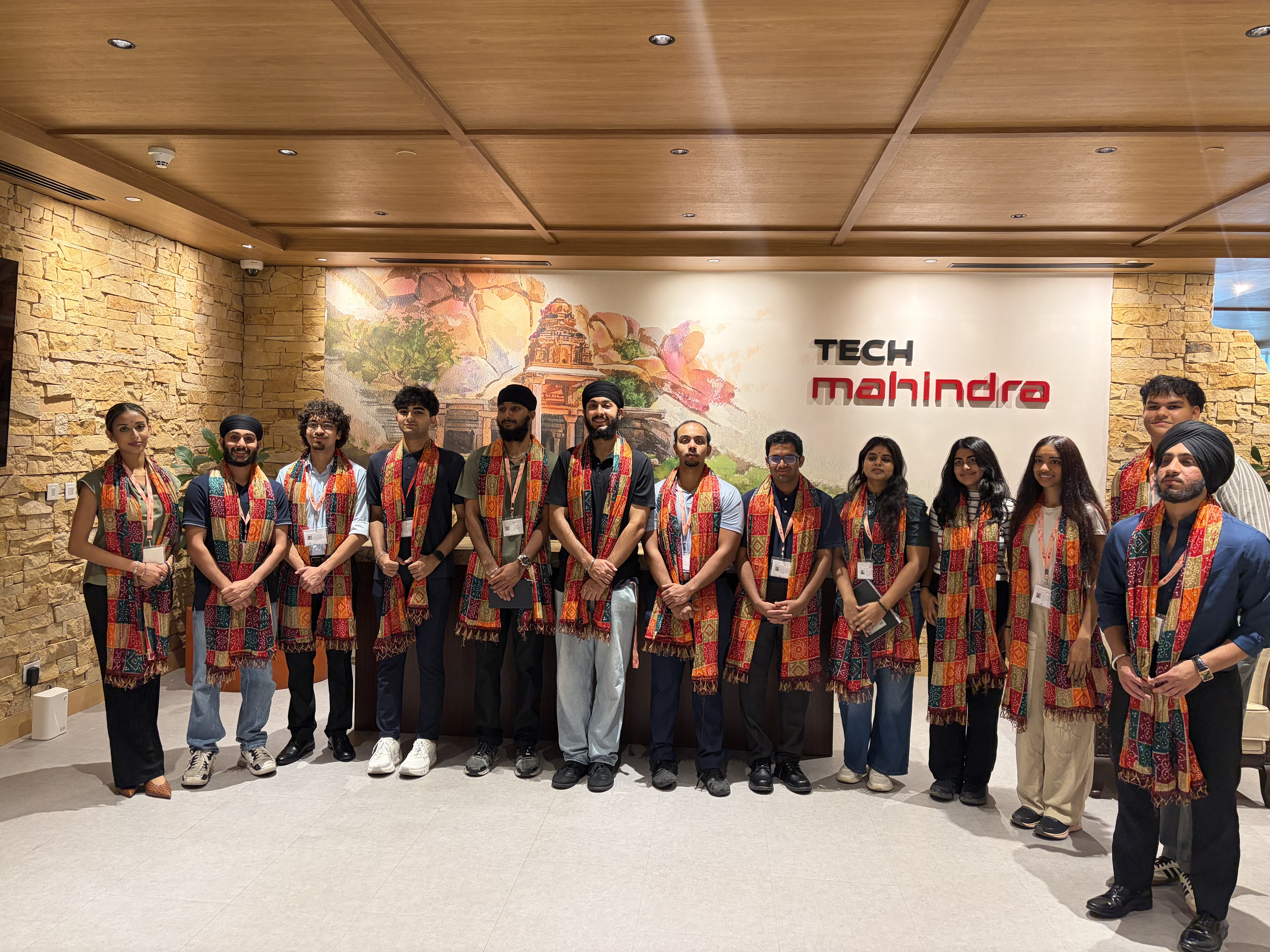 GLP cohort wearing welcome sashes in front of Tech Mahindra headquarters